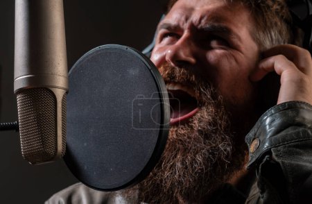 Photo for Expressive face closeup. Singer singing rock. Sound producer recording song in a music studio. Excited Karaoke - Royalty Free Image