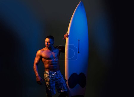 Serfer bodybuilder tenant la planche de serf. Concept de passe-temps. Athlète masculin avec planche de surf. Musclé corps torse de chaud beau garçon