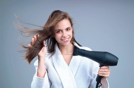 Photo for Woman with hairdryer isolated on studio background. Girl hold hairdryer. Young woman drying hairs with hair dry machine. Beauty girl using hair dryer. Beauti model with holding blow dryer - Royalty Free Image