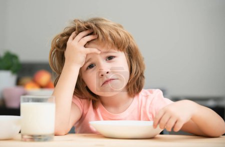 Not hungry. Kid refusing to eat. Child have no appetite. Upset little kid refuse to eat organic cereals with milk. Child nutrition