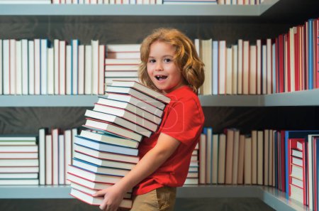 Foto de Gracioso niño sorprendido escuela. Alumno de un niño leyendo un libro en una librería o biblioteca escolar. Estudio para niños leer - Imagen libre de derechos
