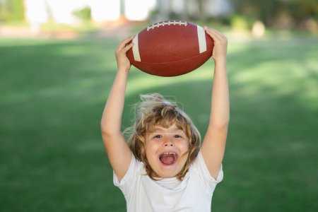 Photo for American boy playing a american football or rugby in park. Sporty kids. Football player holding game ball - Royalty Free Image
