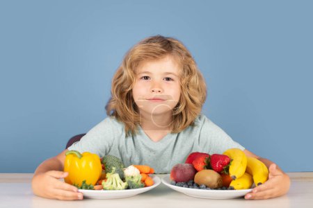 Téléchargez les photos : Enfant avec des fruits et légumes. Les enfants prennent le petit déjeuner. Aliments sains - en image libre de droit