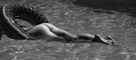 Téléchargez les photos : Sexy women legs on the swimming pool background. Female back and buttocks closeup. Sexy womans body. Summer model. Female ass, huge buttocks - en image libre de droit