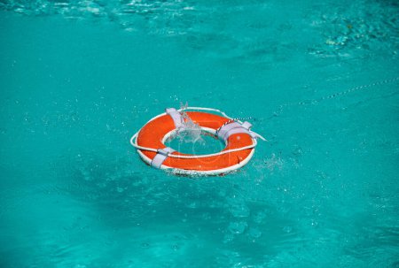 Photo for Lifebelt on sea or pool. Orange inflatable ring floating in blue water. Life buoy for protect and safety drowning - Royalty Free Image