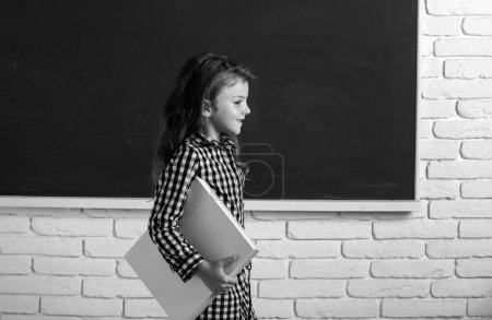 Photo for Cute child at school. Kid is learning in class on background of blackboard. Genius child, knowledge day - Royalty Free Image