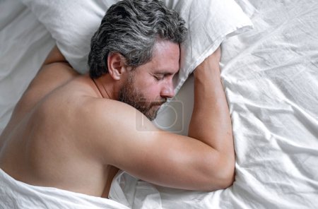 Photo for Adult man sleeps in white bed. Handsome shirtless man sleeping in bed at bedroom. Hispanic mature man sleeping at home at morning. Good sleep. Man sleeping in bed. People bedtime, rest sleep concept - Royalty Free Image