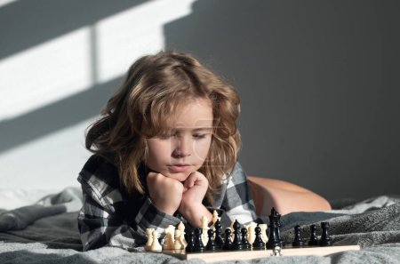 Foto de Juego de ajedrez con niños en casa. Niño jugando al ajedrez. Niño pensando cerca del tablero de ajedrez. Aprendizaje y crecimiento de niños, niños buenos. Desarrollo temprano de niños - Imagen libre de derechos