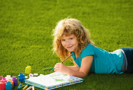 Téléchargez les photos : Artist kids. Child boy enjoying art and craft drawing in backyard or spring park. Children drawing draw with pencils outdoor - en image libre de droit