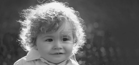 Photo for Baby on spring grass field, banner. Cute little baby on the meadow field. Toddler child walking outdoor, family vacations. Baby face closeup - Royalty Free Image