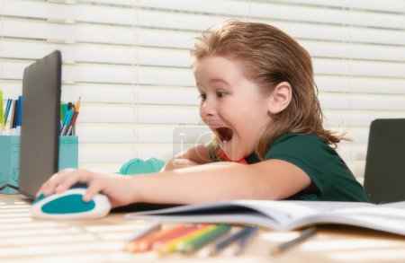 Foto de Alumno escolar que estudia en línea usando el ordenador portátil. Niño asistiendo a la escuela en línea usando computadora - Imagen libre de derechos