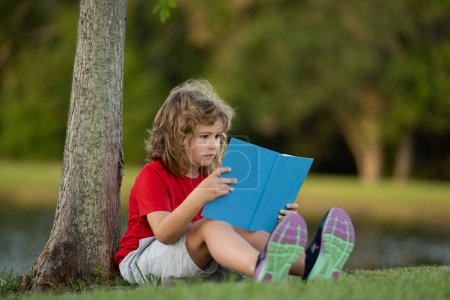 Photo for Child read a book. Elementary outdoor school. Early education for children. Summer vacation homework. Little student outdoor. Children and education concept. Child having picnic in summer park - Royalty Free Image