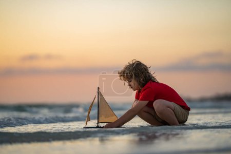 Photo for Child playing with toy boat in sea. Happy holiday by the sea. Little sailor. Kid dreaming about sailing. Happy kid playing with toy sailing boat. Summer vacation. Cute little kid hold toy sailboat - Royalty Free Image