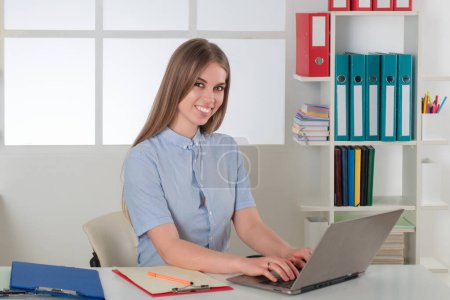 Photo for Accounting audit. Tax Accountant Advisor Man Doing Invoice Accounting. Smiling blonde female accountant in office. Happy Young woman using laptop for calculating reports accounts. Young secretary - Royalty Free Image