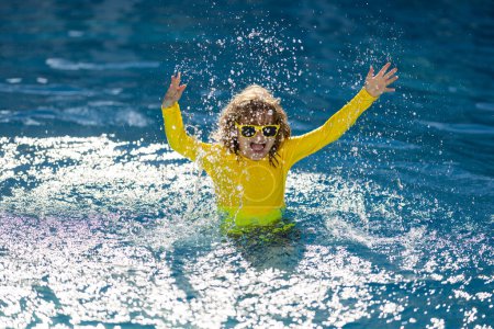 Foto de Niño disfrutando de las vacaciones de verano, nadar en la piscina. Niño nadando y divirtiéndose en las vacaciones de verano. Niños felices nadando en el agua de la piscina. Niños felices nadando en el agua azul en la piscina o en el mar - Imagen libre de derechos