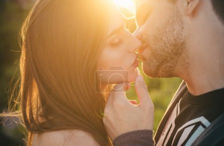 Liebendes Paar, das sich bei Sonnenuntergang im Freien küsst, Liebe und Lebensstil. Sinnlicher Kuss. Junges Paar küsst, Sexy Liebhaber