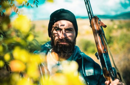 Portrait of hamdsome Hunter. Hunter with shotgun gun on hunt. Man holding shotgun. Big game. Deer hunt