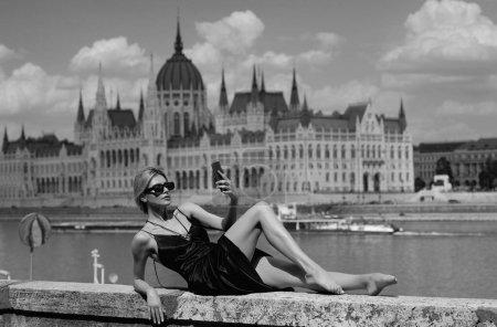 Photo for Sexy woman in sexy fashion dress enjoying the view budapest parliament in hungary. Traveling abroad to travel on weekends getaway. Summer travel. Sexy woman near Budapest Parliament in Hungary - Royalty Free Image