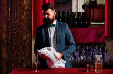 Photo for Barman pouring champagne in champagne glass. Barm an in bar interior making alcohol beverage. Professional bartender - Royalty Free Image