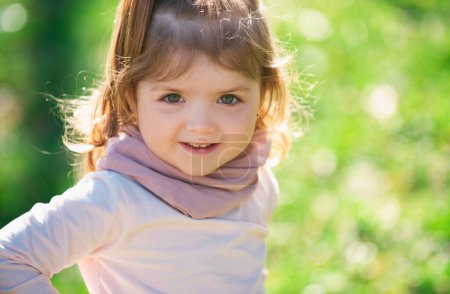 Photo for Baby child girl in grass on the fieald at summer. Baby face closeup. Funny little child close up portrait. Blonde kid, smiling emotion face - Royalty Free Image