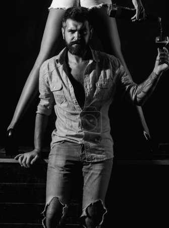 Photo for Couple playing with sexy legs. Handsome man holding womans leg in elegant shoes. Sexy couple tasting wine - Royalty Free Image