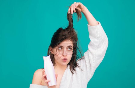 Foto de Sorprendido mujeres asombradas cuidado del cabello. Mujer sostener botella de champú y acondicionador. Chica aplicando acondicionador de cabello - Imagen libre de derechos