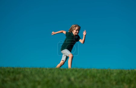 Téléchargez les photos : Enfants heureux jouant et courant sur l'herbe à l'extérieur dans le parc d'été. Enfants actifs sains en plein air. Activité amusante - en image libre de droit
