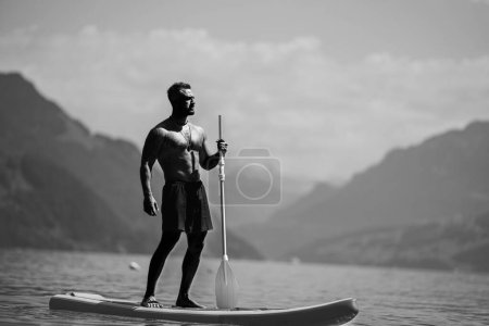 Photo for Man relaxed at the lake. Handsome man with nude torso on the summer beach. Portrait of an sexy man on a Alps lake. Freedom and travel adventure. Sexy traveler is enjoying landscape in Swiss - Royalty Free Image