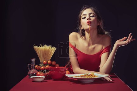 Sexy Woman beißt sinnlich gekochte Spaghetti. Sinnlich wirbeln die Nudeln. Der sinnliche Duft der Pasta bezaubert ihre Sinne. Sexy Mädchen Biss von Spaghetti. Sexy Woman verkostet Spaghetti mit Reiz