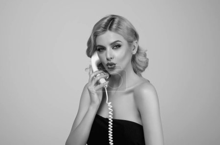 Photo for Sexy woman talking on retro line phone. Portrait of woman holding vintage telephone. Pinup girl with phone handset. Retro vintage phone handset. Pinup style girl holding telephone tube, phone handset - Royalty Free Image