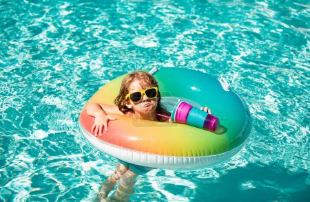Foto de Chico divertido en la piscina bebida cóctel. Vacaciones de verano para niños. Un chico en Aquapark. Infancia - Imagen libre de derechos