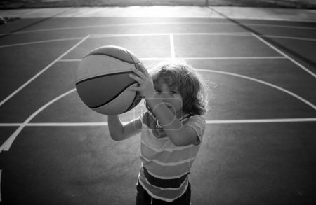 Téléchargez les photos : Enfant garçon jouant au basket-ball avec balle de basket - en image libre de droit