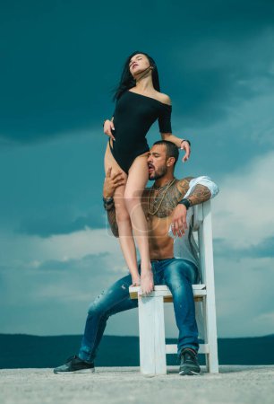 Photo for Couple sex game. Dominantning in the foreplay sexual game. Froup playing domination games. Young fashion mans legs in jeans. Sexy evening for young couple and sex protection - Royalty Free Image