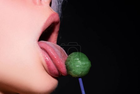 Photo for Licking candy. Lollipop model. Woman lips sucking a candy. Glamor sexy model with red lips eat sweats lolly pop - Royalty Free Image