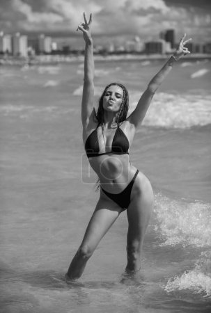Téléchargez les photos : Femme à Miami Beach. Belle fille bronzée en maillot de bain bikini sur fond de mer. Bronzage, vacances et beauté. Jeune femme de mode se détendre sur la plage. Bon style de vie d'été - en image libre de droit