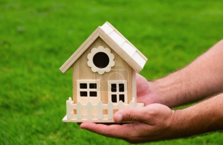 Foto de Mano masculina sosteniendo el modelo de casa de cerca. Pequeña casa de juguete en miniatura. Hipoteca propiedad sueño mudanza casa y concepto de bienes raíces - Imagen libre de derechos