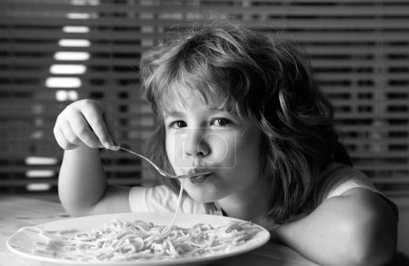 Photo for Caucasian child eating pasta, spaghetti. Kids funny face - Royalty Free Image