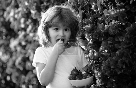Foto de Lindo bebé feliz con fresa, al aire libre - Imagen libre de derechos