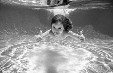 Photo for Underwater child swim in water swimming pool has fun under water on summer vacation - Royalty Free Image