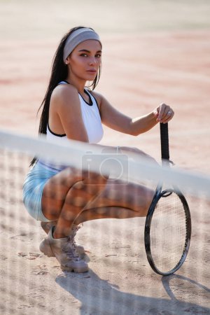 Téléchargez les photos : Femme jouant au tennis. Jolie femme posant avec raquette de tennis et balle. Concept de vie sportive. Joueuse de tennis sexy posant sur le court. Sportive réussie avec raquette sur le court de tennis - en image libre de droit