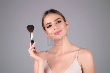 Photo for Beautiful woman applying make-up powder on the cheek. Cosmetic powder brush. Perfect skin and natural makeup - Royalty Free Image