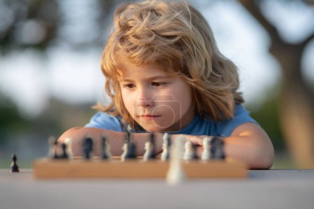 Chess game for children. Kid playing chess. Games and activities for children. Boy and chess, closeup portrait