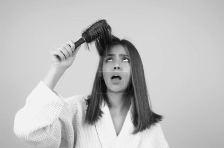 Sad girl with damaged hair. Haircare problem. Woman with hair loss problem. Portrait of young woman with a damaged bad hair. Girl with a hairbrush loosing hairs. Hair loss problem. Alopecia