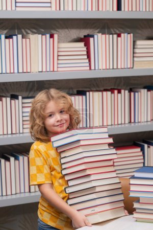 Photo for Back to school. School kid pupil studying in school library. Child reading book in library on bookshelf background - Royalty Free Image
