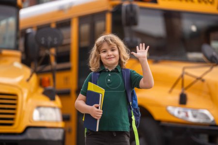 Foto de Child getting on the school bus. American School. Back to school. Bye bye. Kid of primary school. Happy children ready to study - Imagen libre de derechos