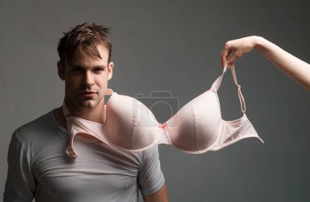 Henpecked husband obey his dominatrix wife and feel himself loser. Man with bra on neck instead of lead. Dominance and relationship problems of married couple concept