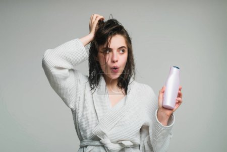 Photo for Woman touching her hair. After showering. Woman hold bottle shampoo and conditioner - Royalty Free Image
