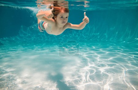 Happy kid swims in pool underwater, active kid swimming underwater, playing and having fun, Children water sport. Vacation and traveling with kids. Children play outdoors in summer water