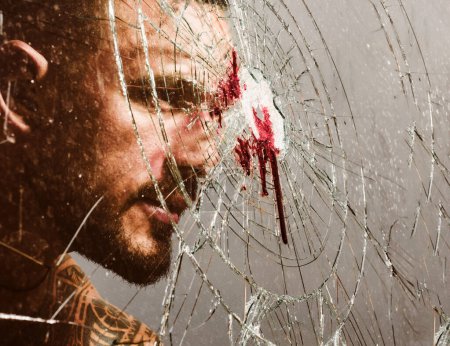 Strong horny man breaking window glass. Bloodstains at broken crushed glass. Blood stain at smashed window glass. Mens power and strength. Mens style and fashion concept