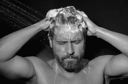 Retrato de hombre lavando el cabello con champú tomando ducha. Lavar el cabello con champú. Hombre lavando el cabello con champú anti-caspa, tomando una ducha. Producto para el cuidado del cabello, gel de espuma, champú y loción
